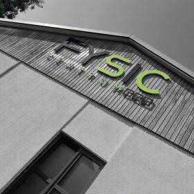 Seitenanblick des Hauses mit Logo in schwarz-grünen Buchstaben